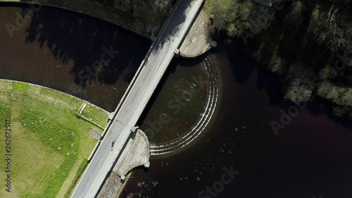 Static Aerial Shot of Cyclist Crossing Dam in Yorkshire, England photo