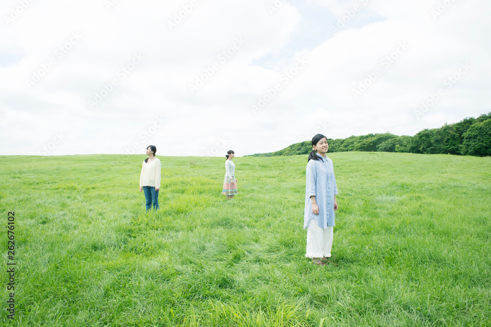 草原に佇む3人の女性
