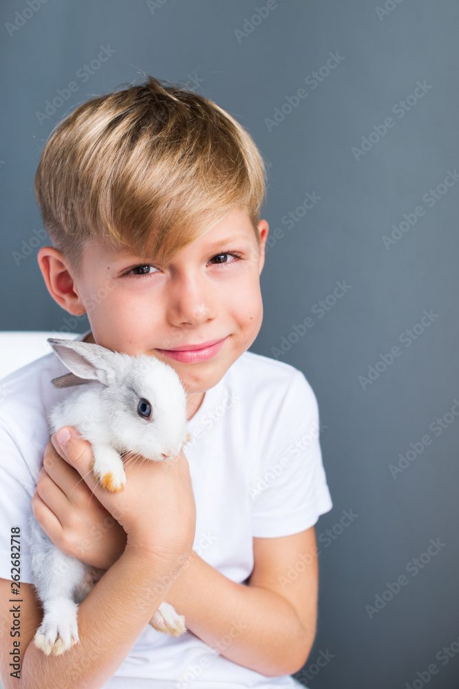 Little boy white Tshirt and tame dwarfish rabbit