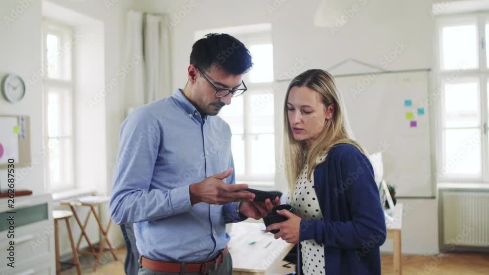 Group of young businesspeople with smartphone working together in a modern office. Group of young businesspeople with smartphone working together in a modern office.