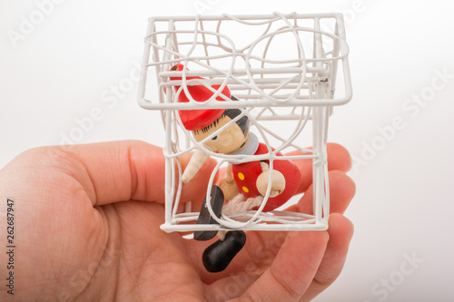 Hand holding a model house with pinocchio in