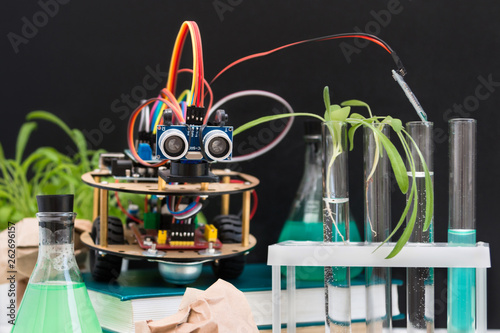 Robot handmade in the laboratory. Here are the plants, test tubes, microscope all around. STEM and STEAM education. An experiment in biology, robotics, chemistry, physics and mathematics.