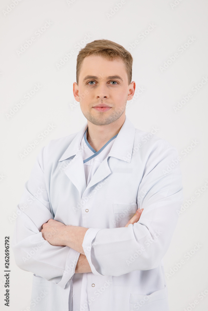 Medical staff. Young sympathetic doctor stands isolated on a white background dressed in a uniform for doctors Medical staff. Young sympathetic doctor stands isolated on a white background dressed in a uniform for doctors