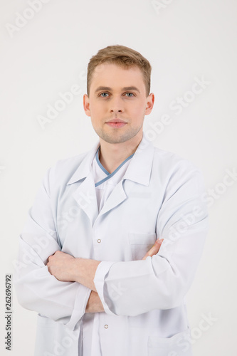 Medical staff. Young sympathetic doctor stands isolated on a white background dressed in a uniform for doctors © nazariykarkhut