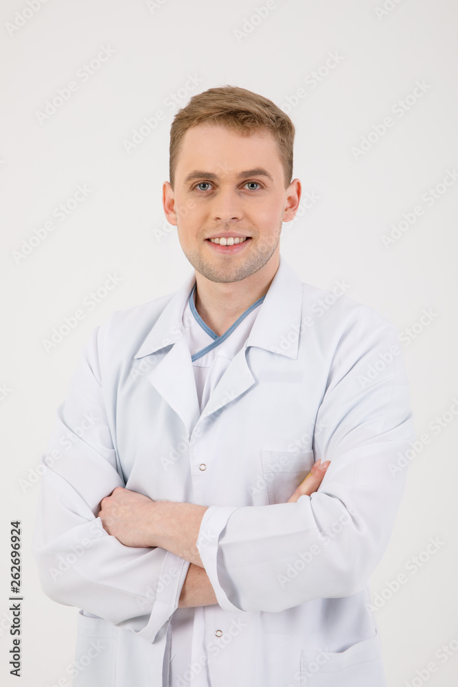 Medical staff. Young sympathetic doctor stands isolated on a white background dressed in a uniform for doctors Medical staff. Young sympathetic doctor stands isolated on a white background dressed in a uniform for doctors