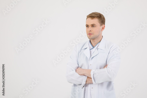 Medical staff. Young sympathetic doctor stands isolated on a white background dressed in a uniform for doctors © nazariykarkhut