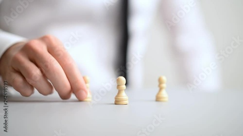 Businessman placing pawn chess pieces on office desk