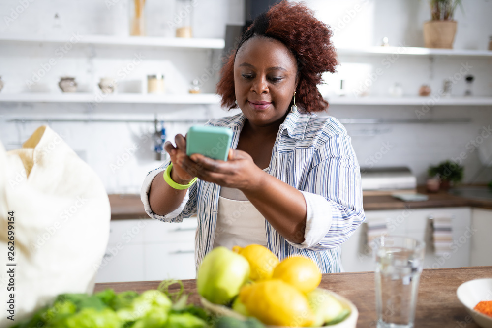 Cheerful housewife doing top view picture on her gadget