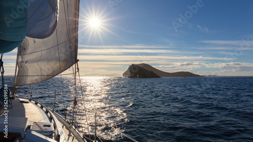 View over the bow of a sailing yacht to Isla Grosa, La Manga and the Mar Menor with the sun as backlight photo