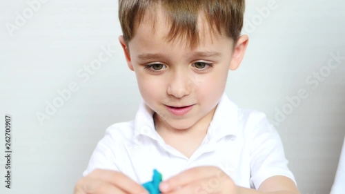 Happy child playing with model mixing, plasticine, dough for work photo