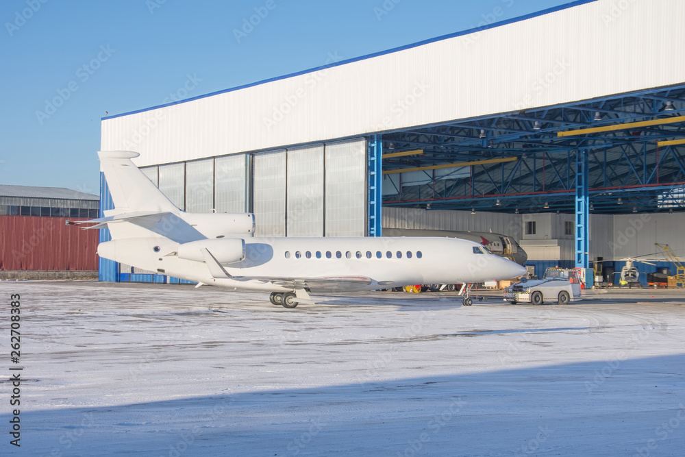 Aircraft is delivered inside via tow-tractor the aviation hangar for maintenance.
