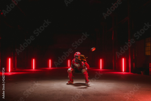 Photography Caucasian professional baseball player catcher posing against dark background in