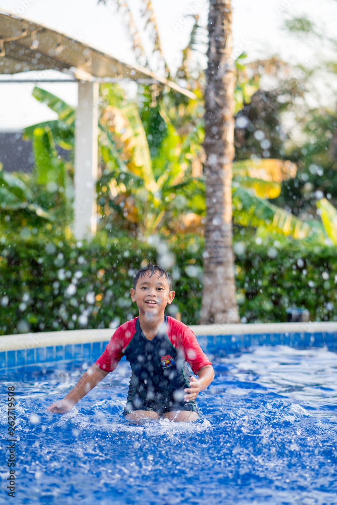 Happy asian kid boy swiming on swiming pool in the summer Happy asian kid boy swiming on swiming pool in the summer