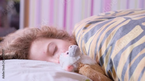 Teen girl sleeping on the bed with a toy monkey