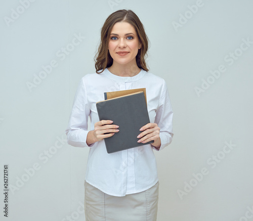 smiling woman in white shirt holding book.