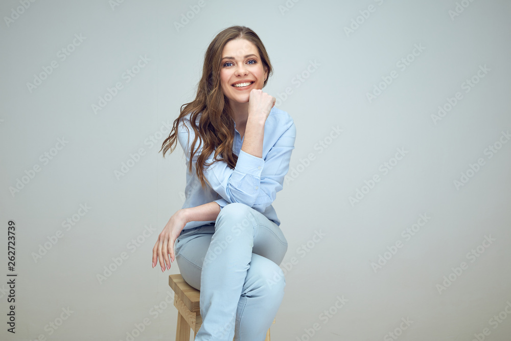 smiling woman with long hair sitting on stool. smiling woman with long hair sitting on stool.