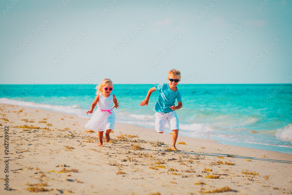 little boy and girl running at beach vacation