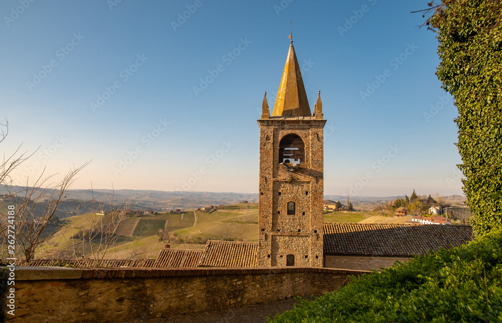 High angle view of the rooftops of the medieval village of Serralunga d'Alba with a brick bell tower and the vineyard hills of the Langhe region, Unesco World Heritage Site, Piedmont, Italy