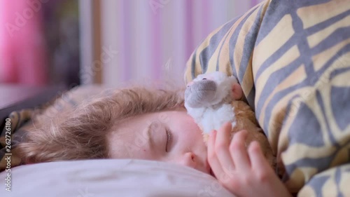 Teen girl sleeping on the bed with a toy monkey