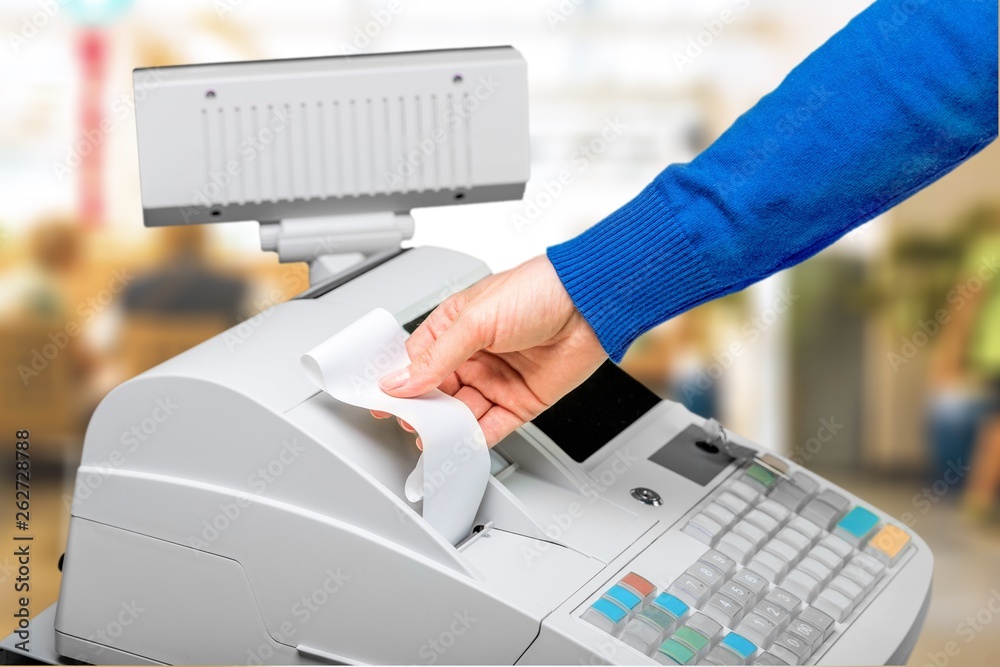 Cash register with LCD display and worker's hand holding receipt paper
