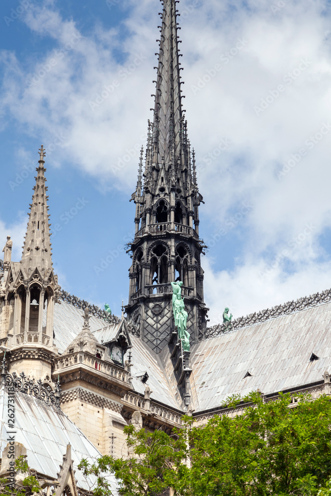 Notre Dame de Paris Cathedral before fire. Fragment of southern facade with copper statues, clock and spire on a roof