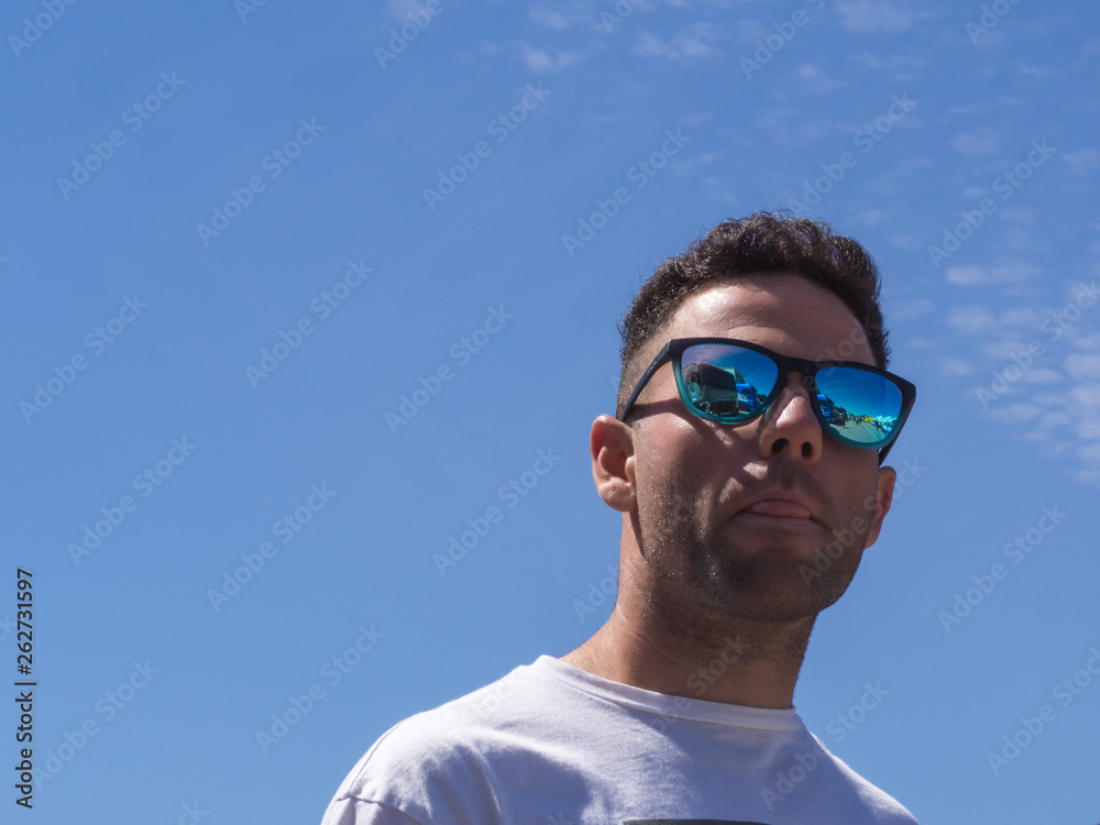 Young man with blue glasses showing his tongue