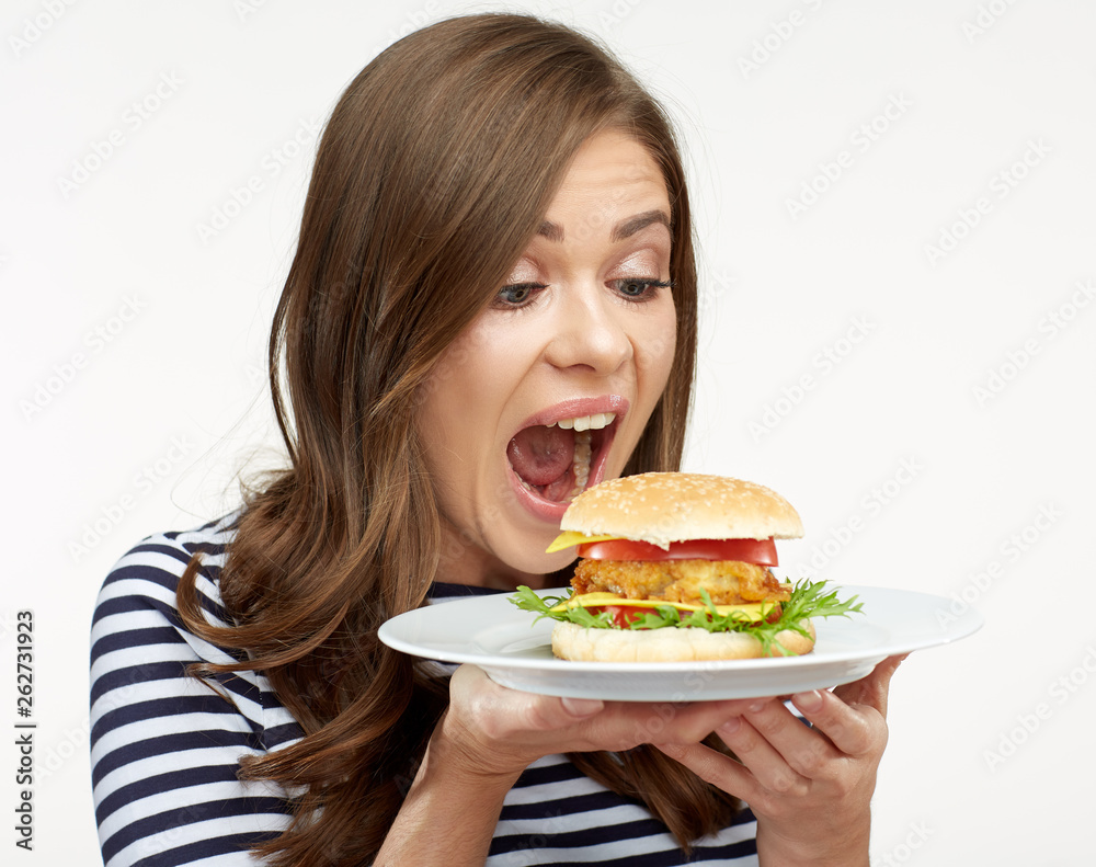 happy woman holding burger on white plate.