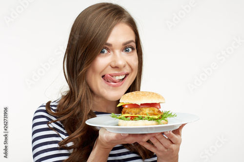 Smiling girl holding white plated with burger.