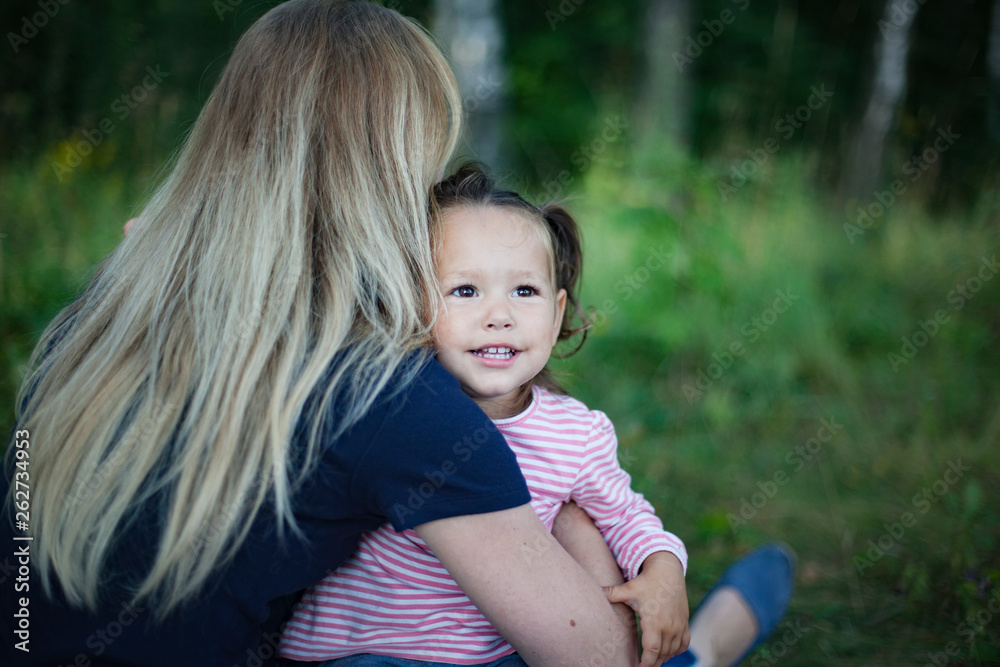 Beautiful woman and her little daughter having fun in the meadow, single mother concept, copy space Beautiful woman and her little daughter having fun in the meadow, single mother concept, copy space
