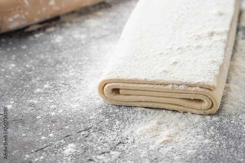 Fresh raw dough on table. Puff pastry. Copy space. photo