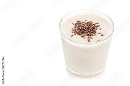 Oat milk in a glass dusted with flax grains