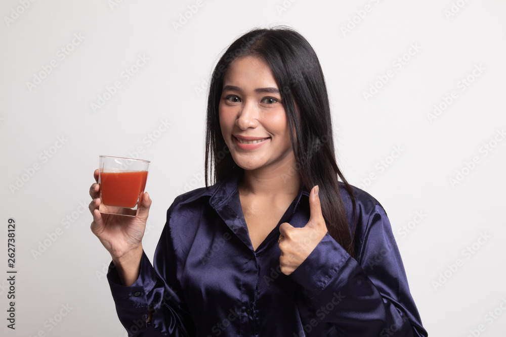 Young Asian woman thumbs up with tomato juice. Young Asian woman thumbs up with tomato juice.