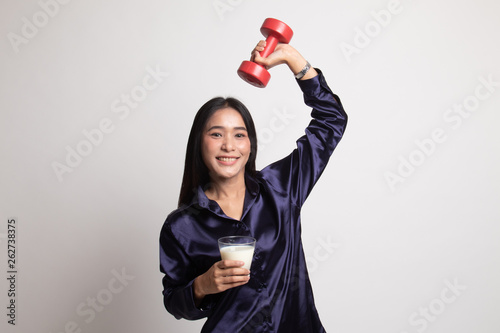 Healthy Asian woman drinking a glass of milk and dumbbell.