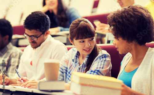 education, high school, university, learning and people concept - group of international students talking on lecture