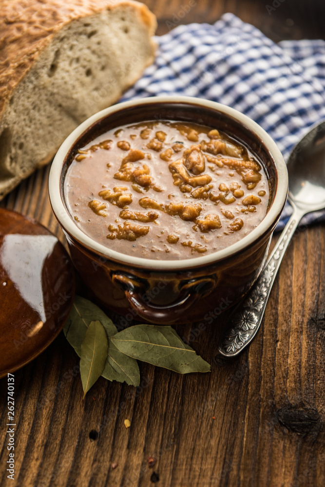 tripe stew sauce in brown ceramic pot on a wood table tripe stew sauce in brown ceramic pot on a wood table
