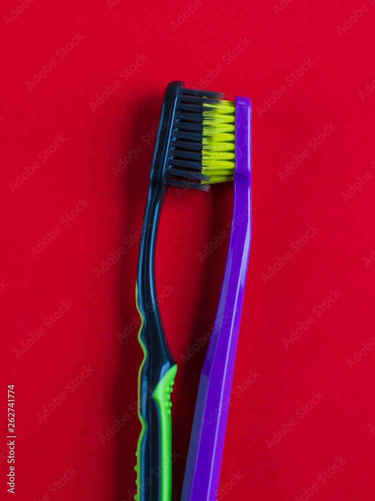 multicolored toothbrushes on a red background multicolored toothbrushes on a red background