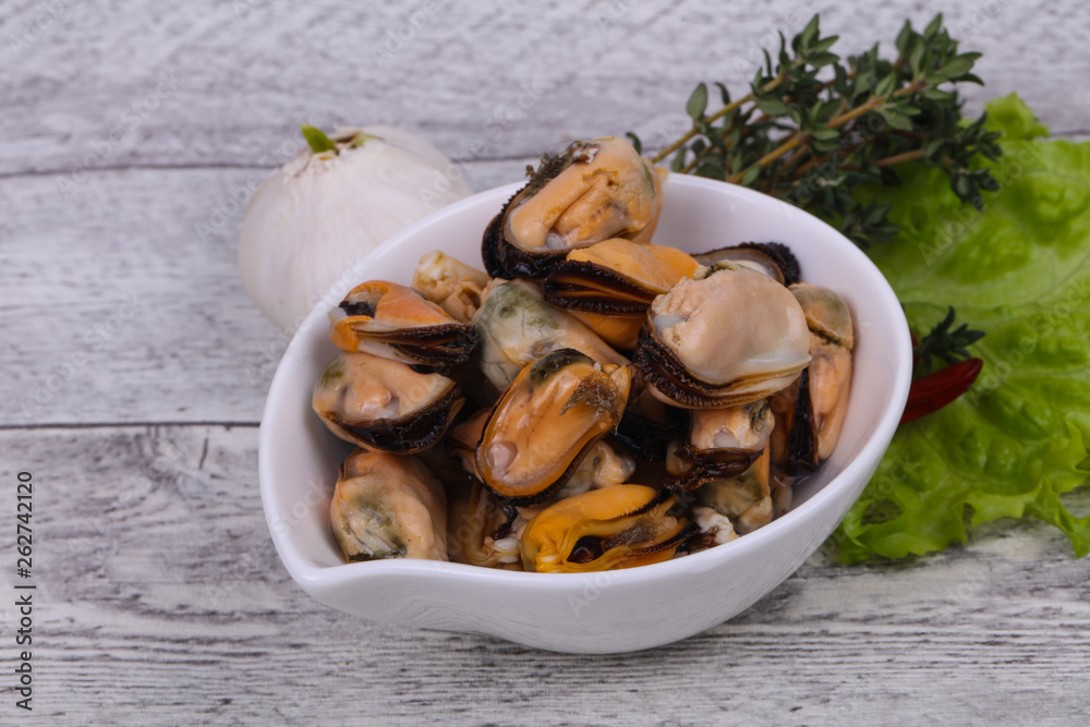 Pickled mussels in the bowl served pepper, garlic and salad Pickled mussels in the bowl served pepper, garlic and salad
