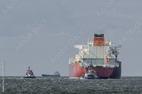 LNG TANKER - The ship is sailing along the waterway in the Tug boats
