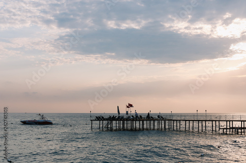 A pontoon on the mediterranean sea at sunset. Sea horizon and sunset sky. Vacation concept.