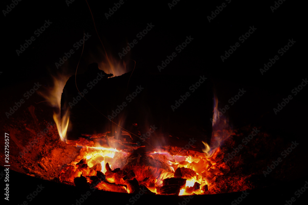 Lagerfeuer in der Nacht mit Flammen um großes Holzstück Lagerfeuer in der Nacht mit Flammen um großes Holzstück