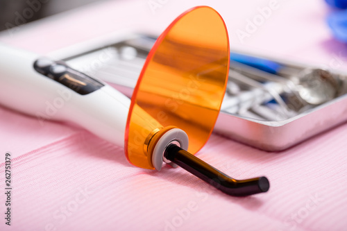 Foto Dental curing light and sterilized dental instruments on a tray close-up