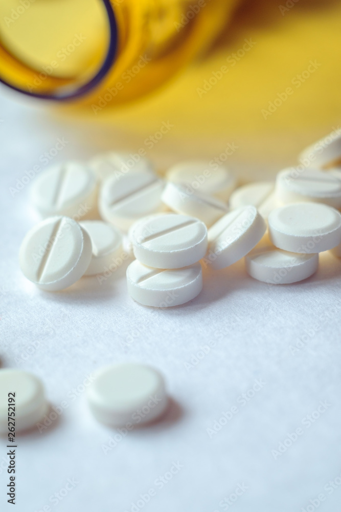 White pills in a yellow glass jar. Medicine, health care, pharmacy White pills in a yellow glass jar. Medicine, health care, pharmacy