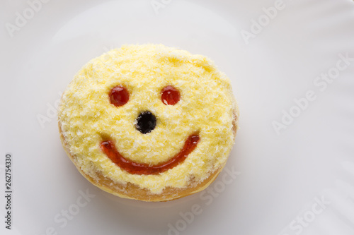 Smiley donut on a white plate, donut with white background .