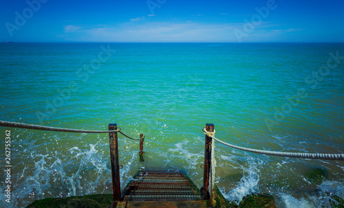 Bild auf Leinwand Wooden and iron stairs with rope railings to the turquoise water in Mediterranea