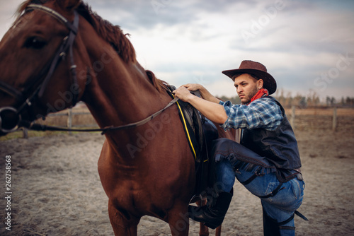 Brutal cowboy climbs on horseback on texas ranch © Nomad_Soul