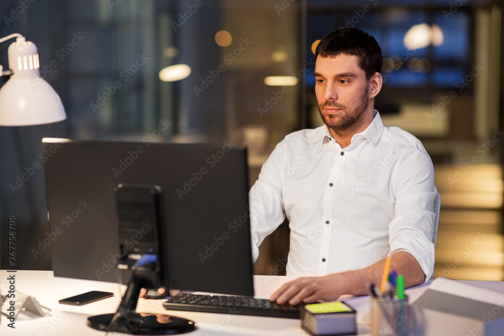 business, overwork, deadline and people concept - businessman with computer working at night office business, overwork, deadline and people concept - businessman with computer working at night office