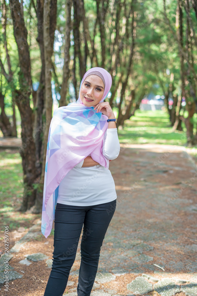Portrait of lovely young Malay woman, modern stylish Muslim fashion, nature background. Selective focus. Portrait of lovely young Malay woman, modern stylish Muslim fashion, nature background. Selective focus.