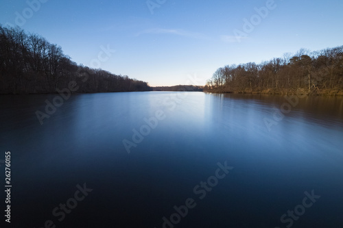 Calm forest lake early in the morning. The Sun slowly rising