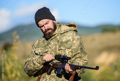 Focus and concentration of experienced hunter. Hunting and trapping seasons. Hunting masculine hobby. Man brutal gamekeeper nature background. Bearded hunter spend leisure hunting. Hunter hold rifle