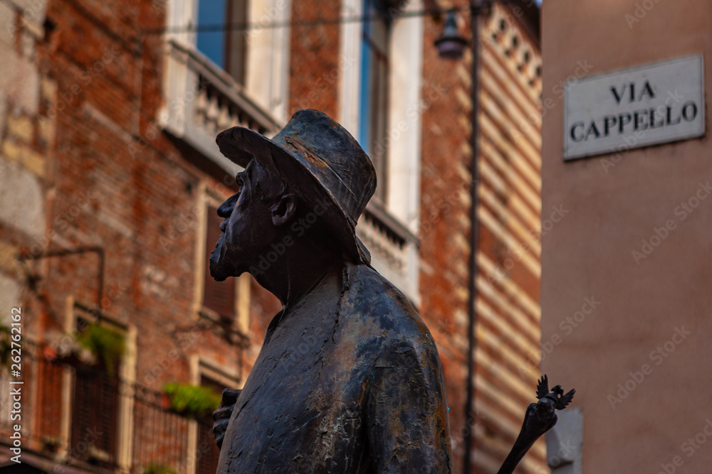 Naklejka premium Verona, Italy – March 2019. Statue of Berto Barbarani at Historic town Elbe square with stairs surrounded by cafes and buildings of peculiar architecture